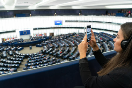 Henkilö kuvaa kameralla Euroopan parlamenttia